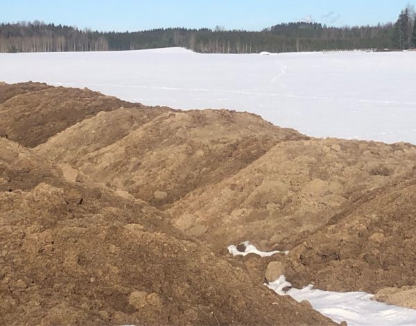 maanparannusainetta kasoissa lumisella pellolla