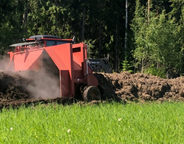 Traktorilla käännetään kompostia pellolla