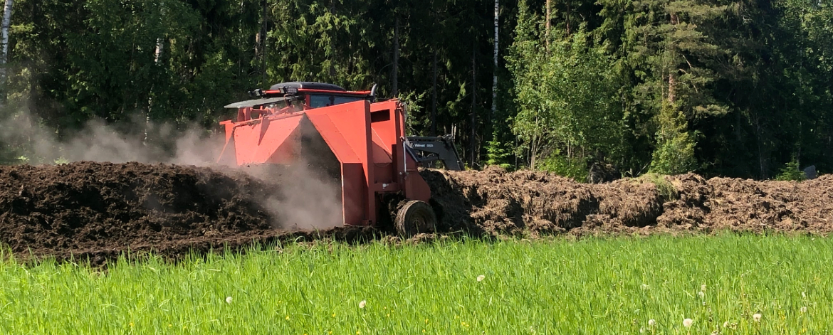 Traktorilla käännetään kompostia pellolla